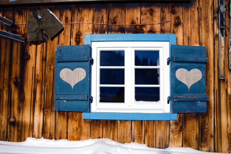Protect Your Plumbing From Freezing Weather. House with blue shutters in snow.