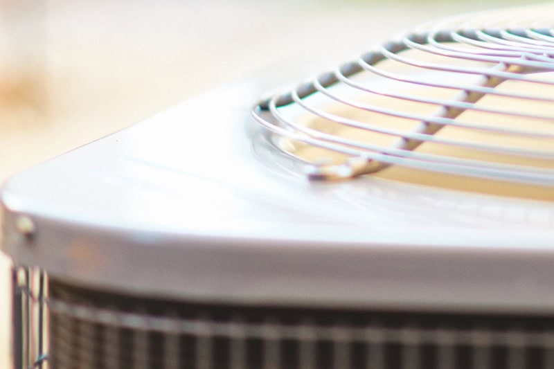 4 Important Heat Pump Maintenance Tips. A heat pump system on a sunny day.
